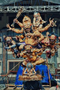 Intricate balinese statue of a multi-armed deity and figures.