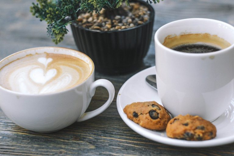 cup of black coffee and two cookies on saucer
